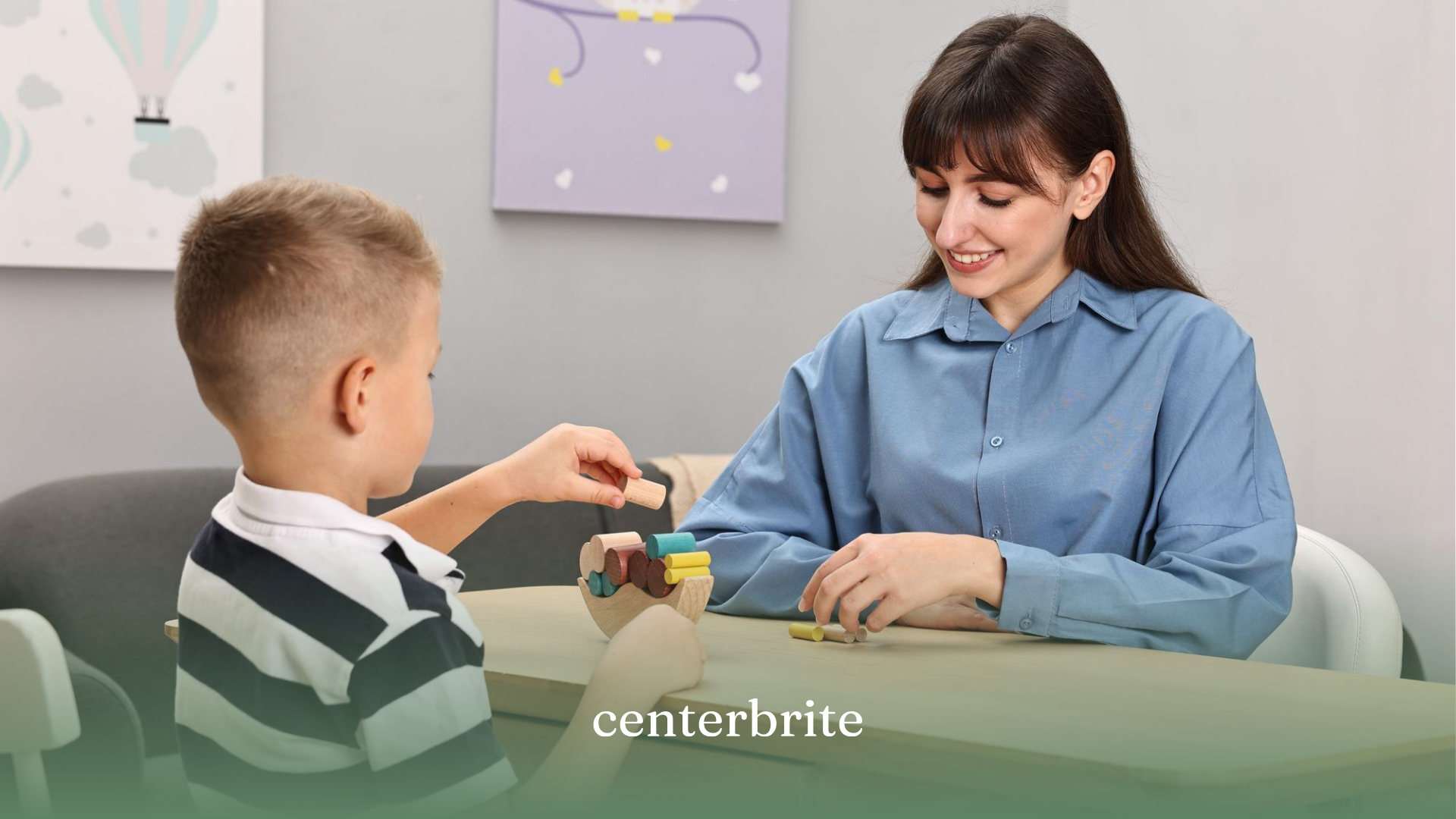 A kid playing with wooden toys on a table while an ABA therapist sit in front of him