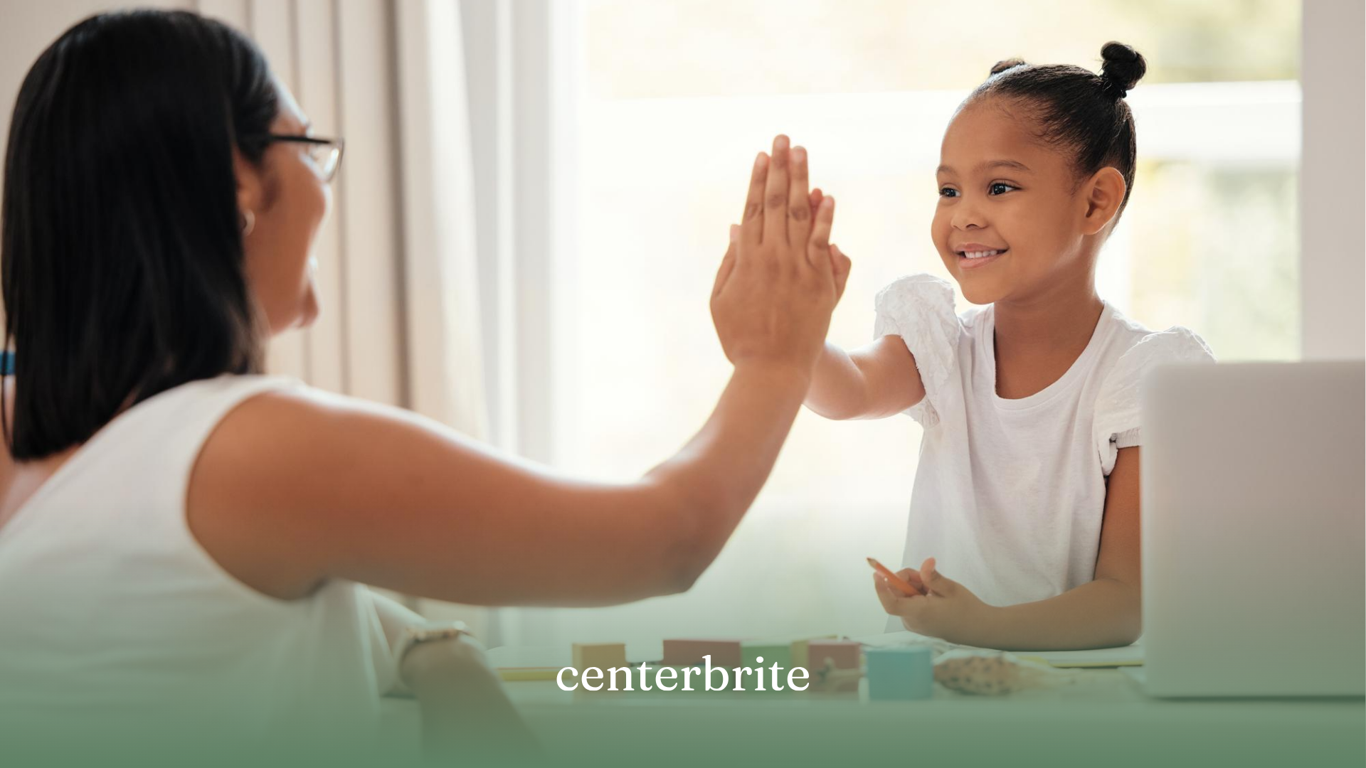 A kid happily high-fiving her ABA therapist during ABA therapy
