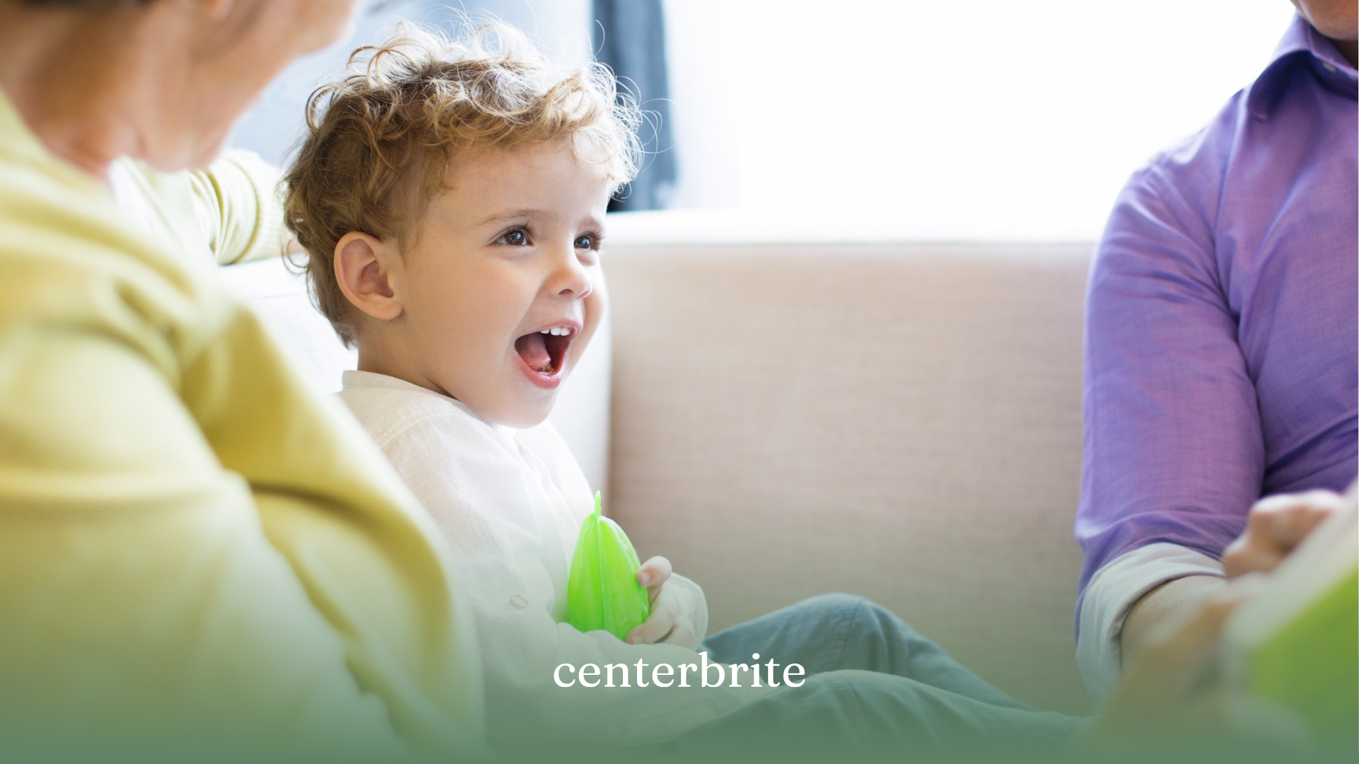 A toddler smiling while interacting with an ABA therapist