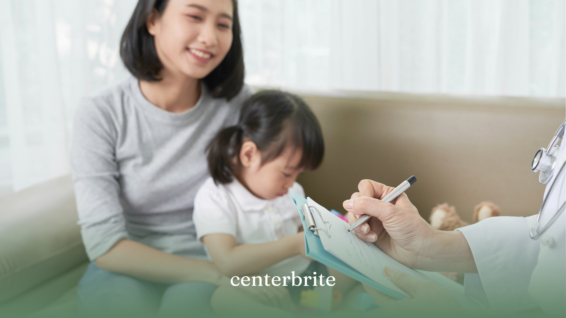 A mother with her child talking to a BCBA jotting down notes on a clipboard